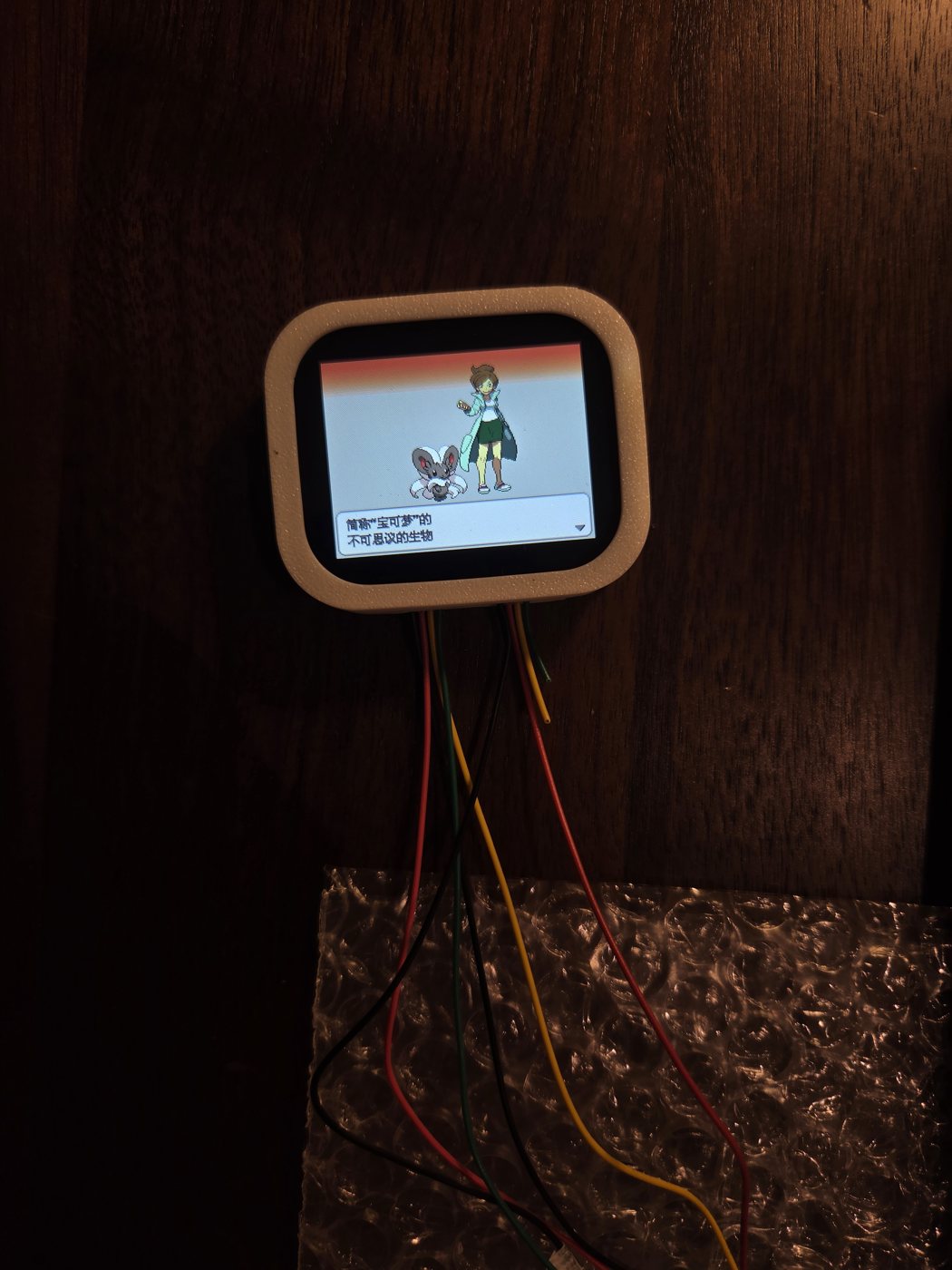 The small screen in its printed frame showing a DS game's opening scene