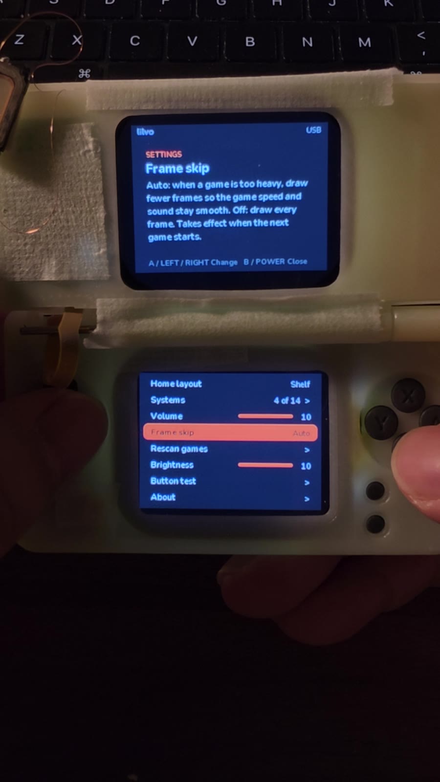 Prototype held in hand, both screens on, settings menu visible